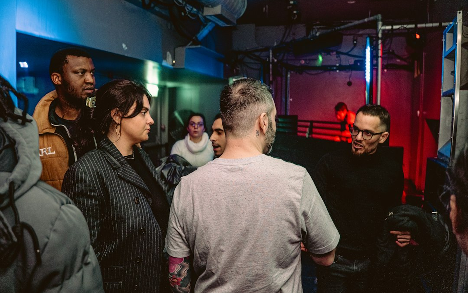 Crew briefing around a plan before an event, in a dark venue