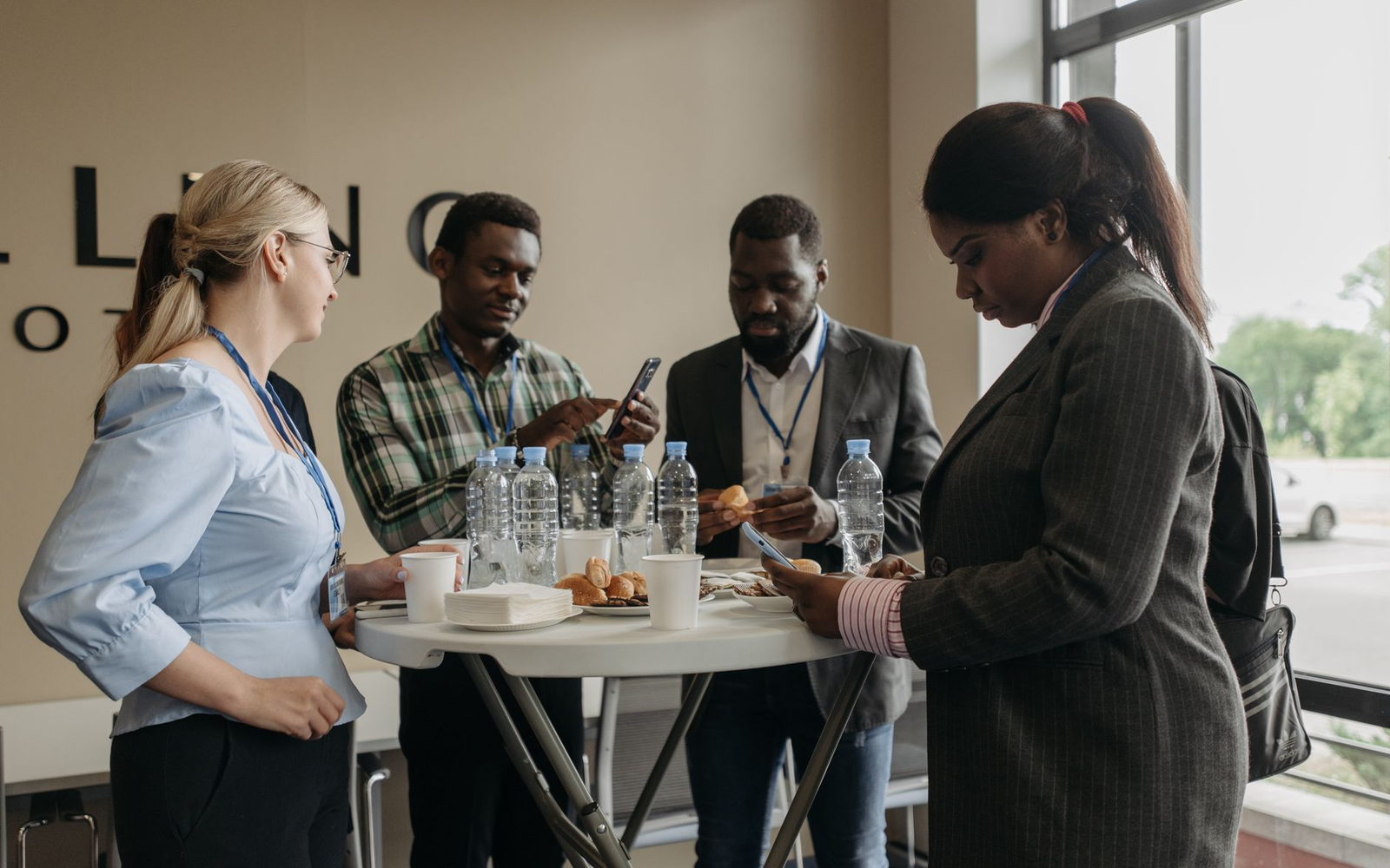 Mixed groups of adult colleagues competing at small entertainment tables with a facilitator moving between them